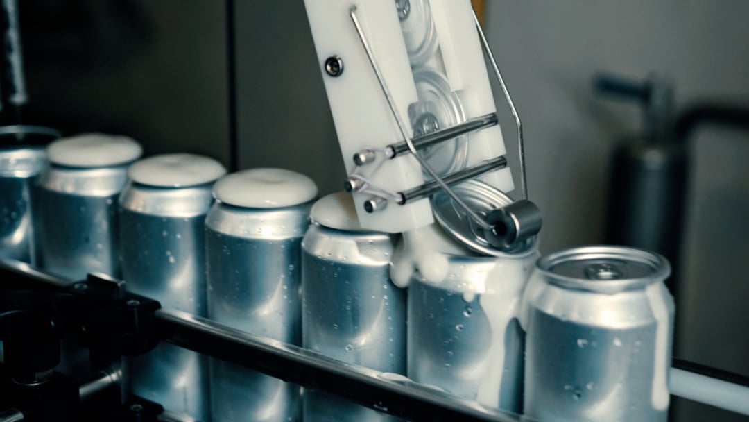 packaging_lids-placed-on-cans-conveyor_1080x608